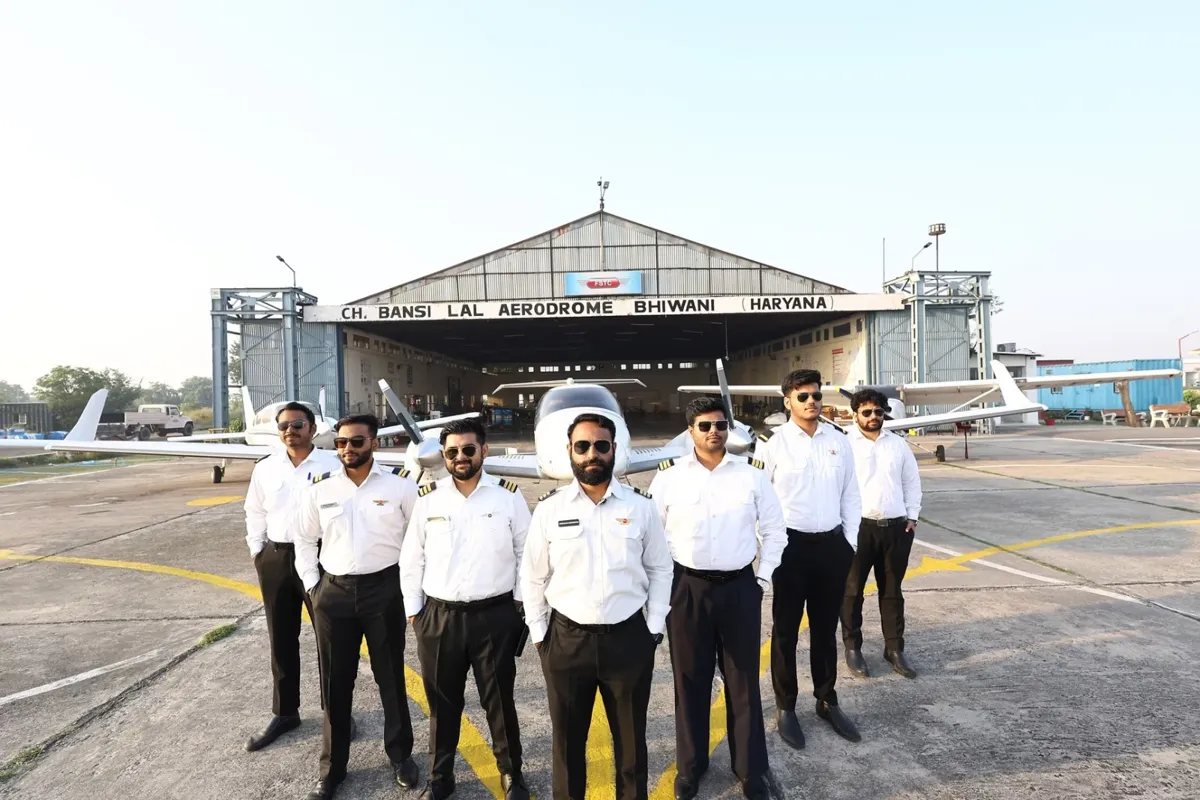 FSTC Flying School cadets in front of a training aircraft and hangar in Haryana